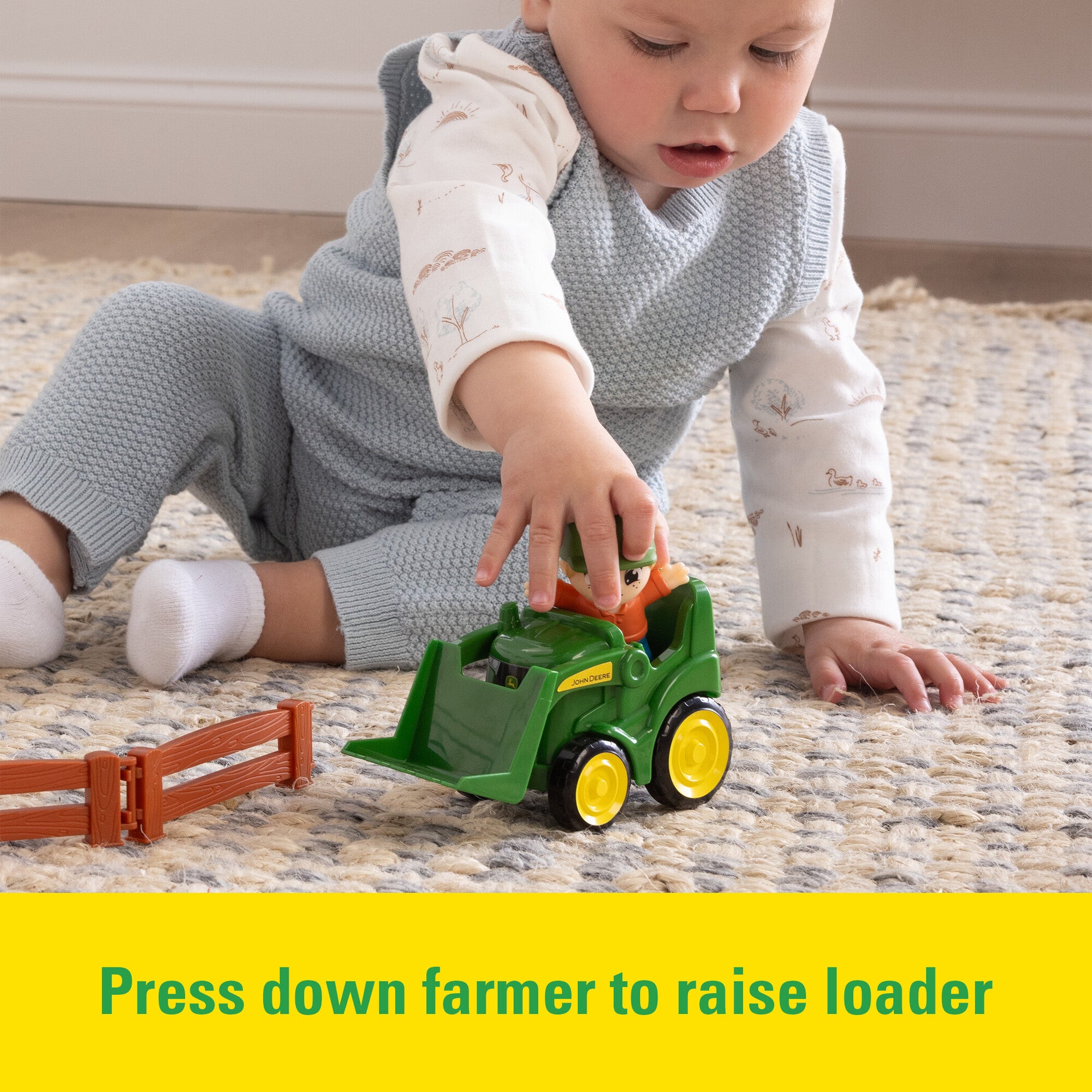 Toddler pushing a John Deere Toy Front loader from the The Cows Are Out Playset