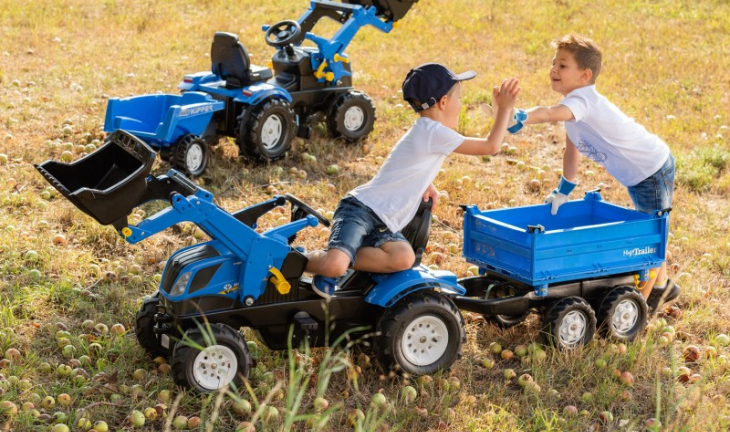 Child playing with Rolly Ride on New Holland Tractors Outside