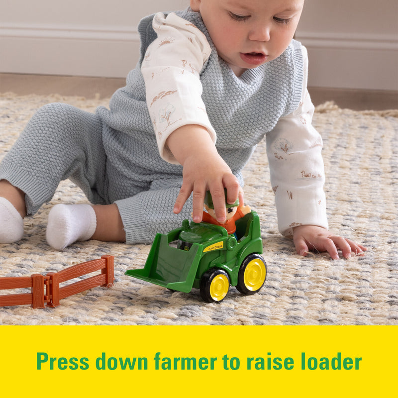Toddler pushing a John Deere Toy Front loader from the The Cows Are Out Playset
